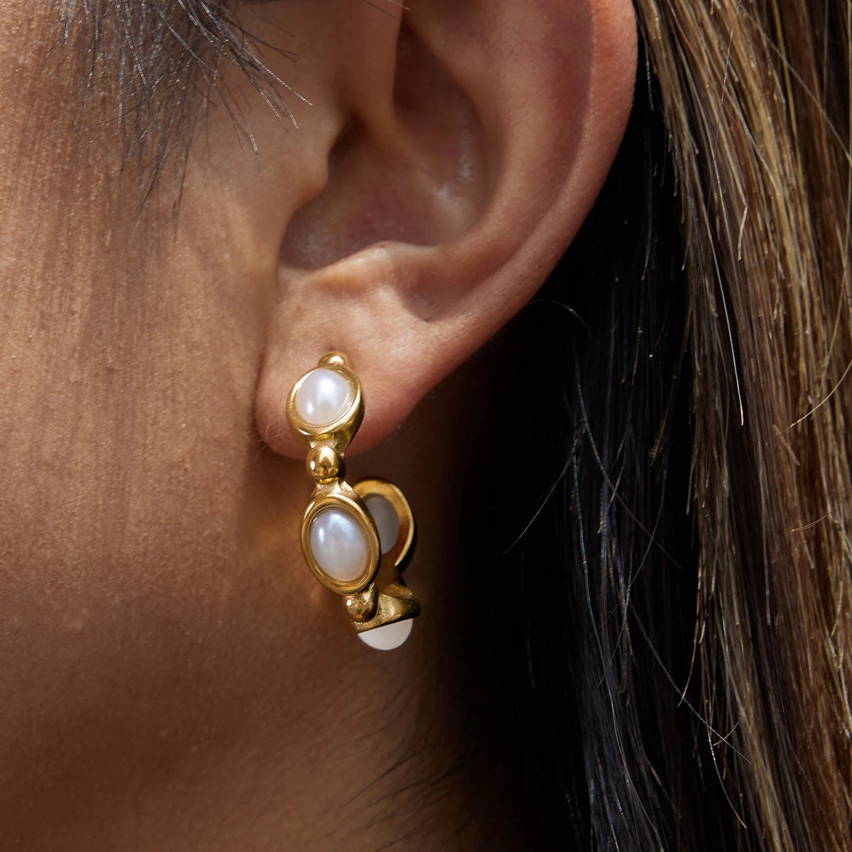 Santorini pearl earrings on model, side