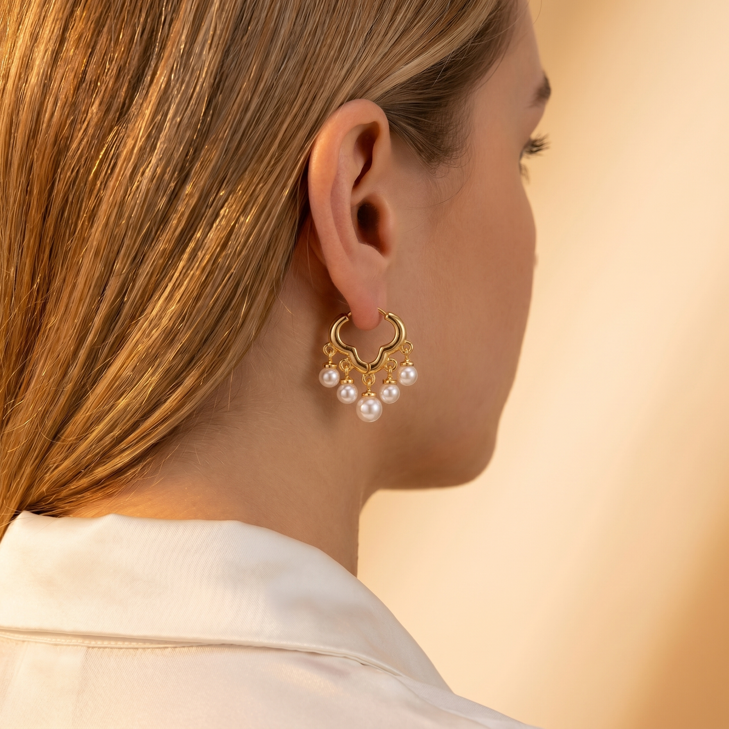 Daisy gold pearl huggie earrings on model