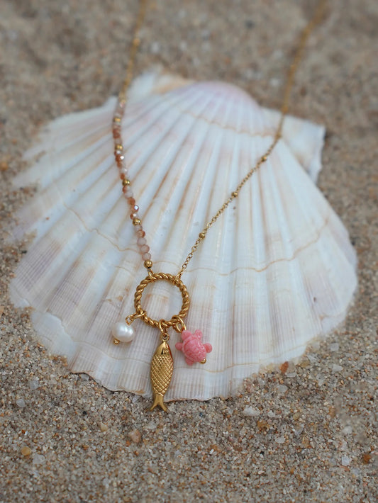 Marina gold-tone fish pendant necklace packshot on seashell