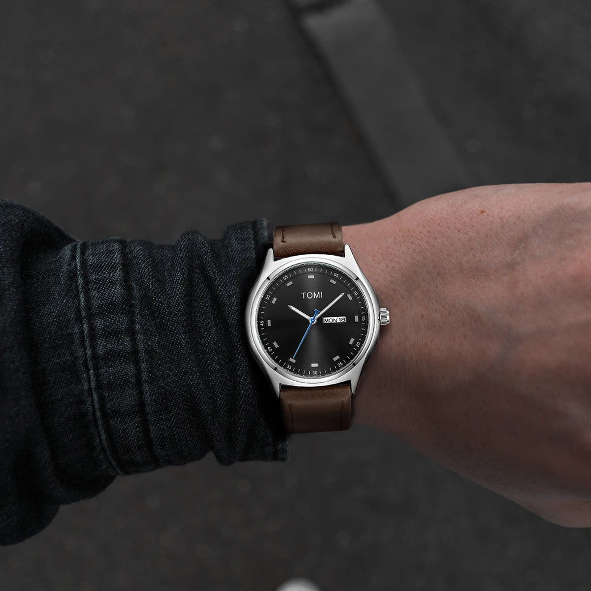 Emerson Minimalist Calendar Watch worn on the wrist, silver case with brown strap