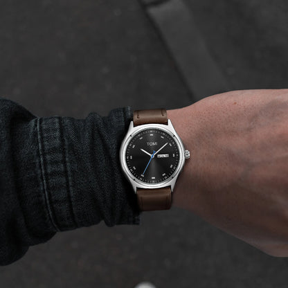 Emerson Minimalist Calendar Watch worn on the wrist, silver case with brown strap