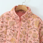 Pink floral-patterned jacket on a hanger against a white background