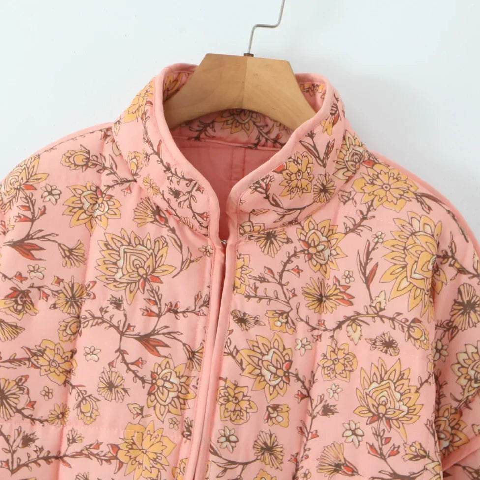 Pink floral-patterned jacket on a hanger against a white background