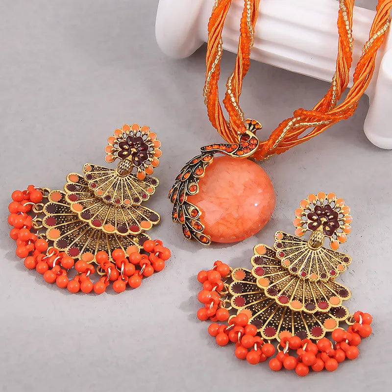 Alba Beaded Peacock Jewelry Set in Coral Orange, necklace and fan earrings flat lay