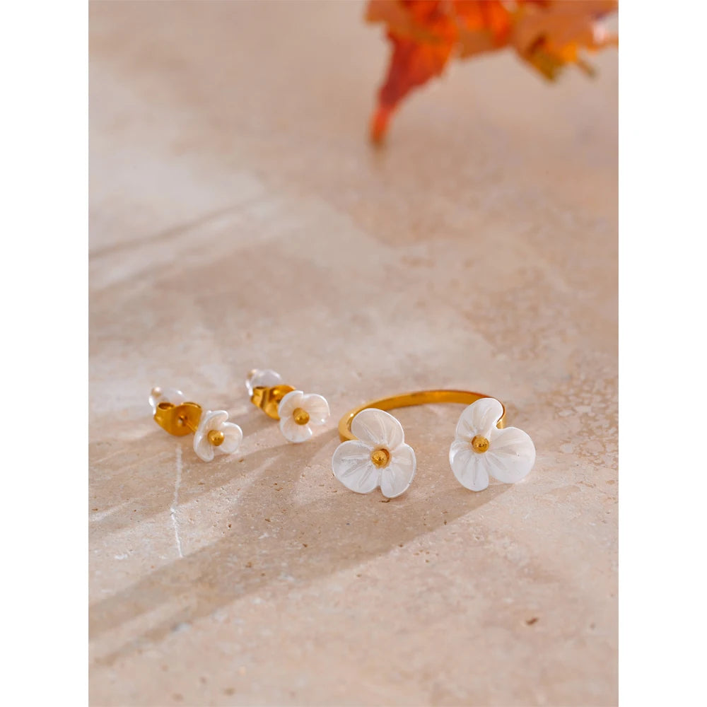 Rhea Blossom white resin flower ring and stud earrings on stone