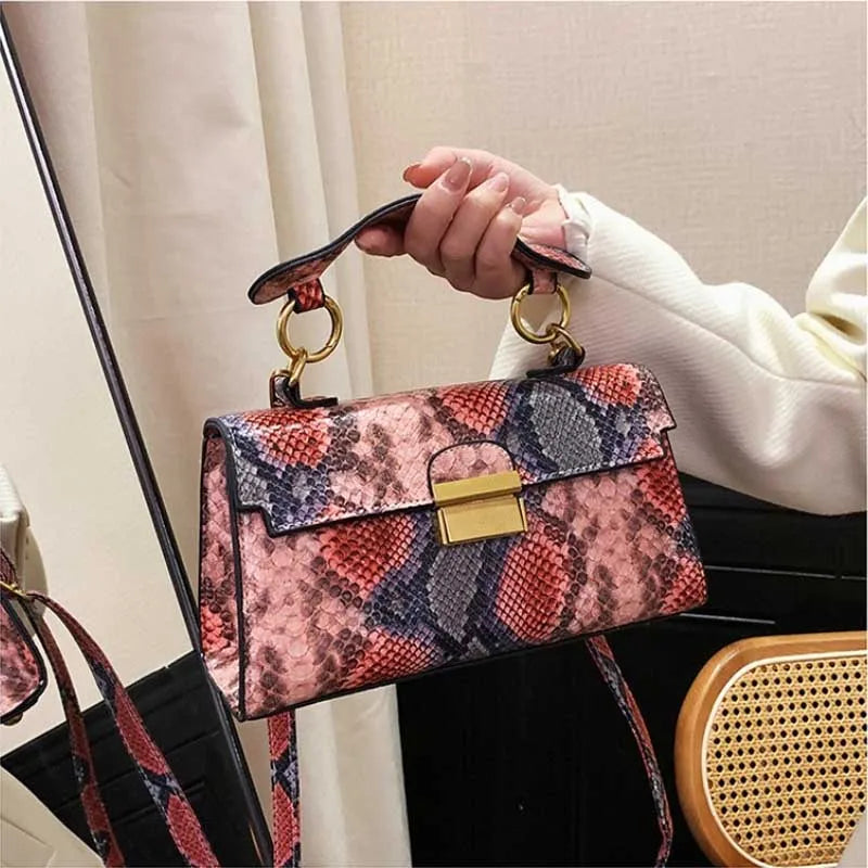 Serra snake-print bag held by hand