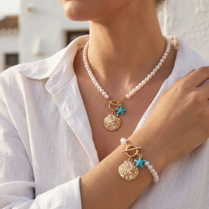 Close view of the Cove imitation pearl strand necklace and matching bracelet worn together