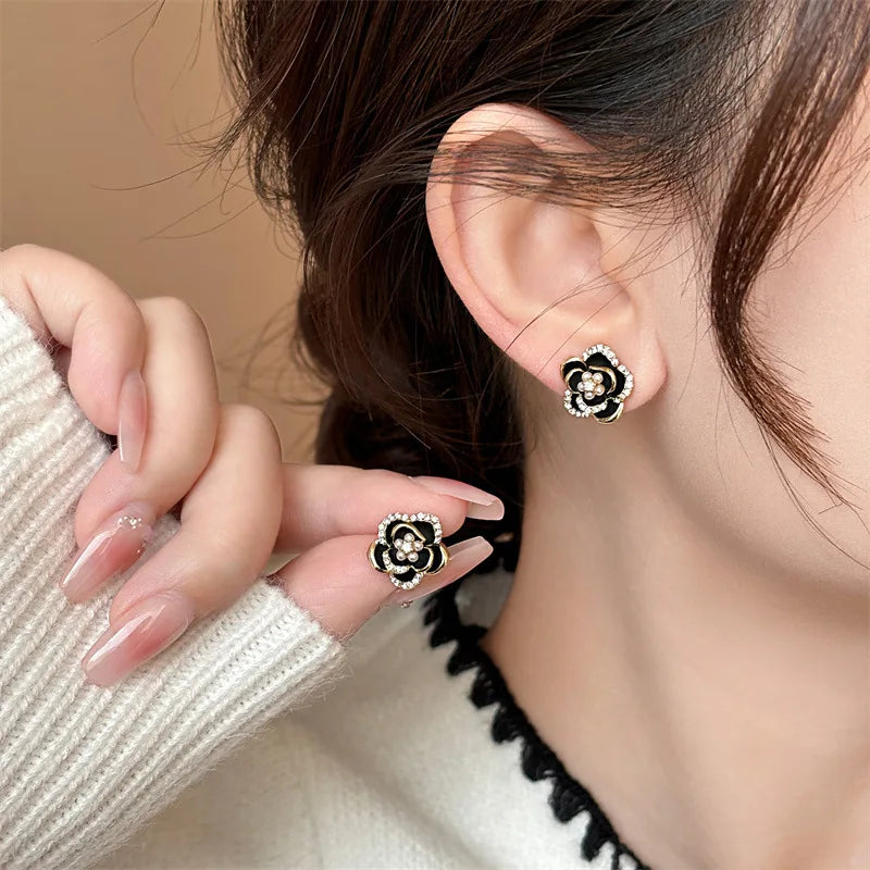 Camellia earrings held in hand