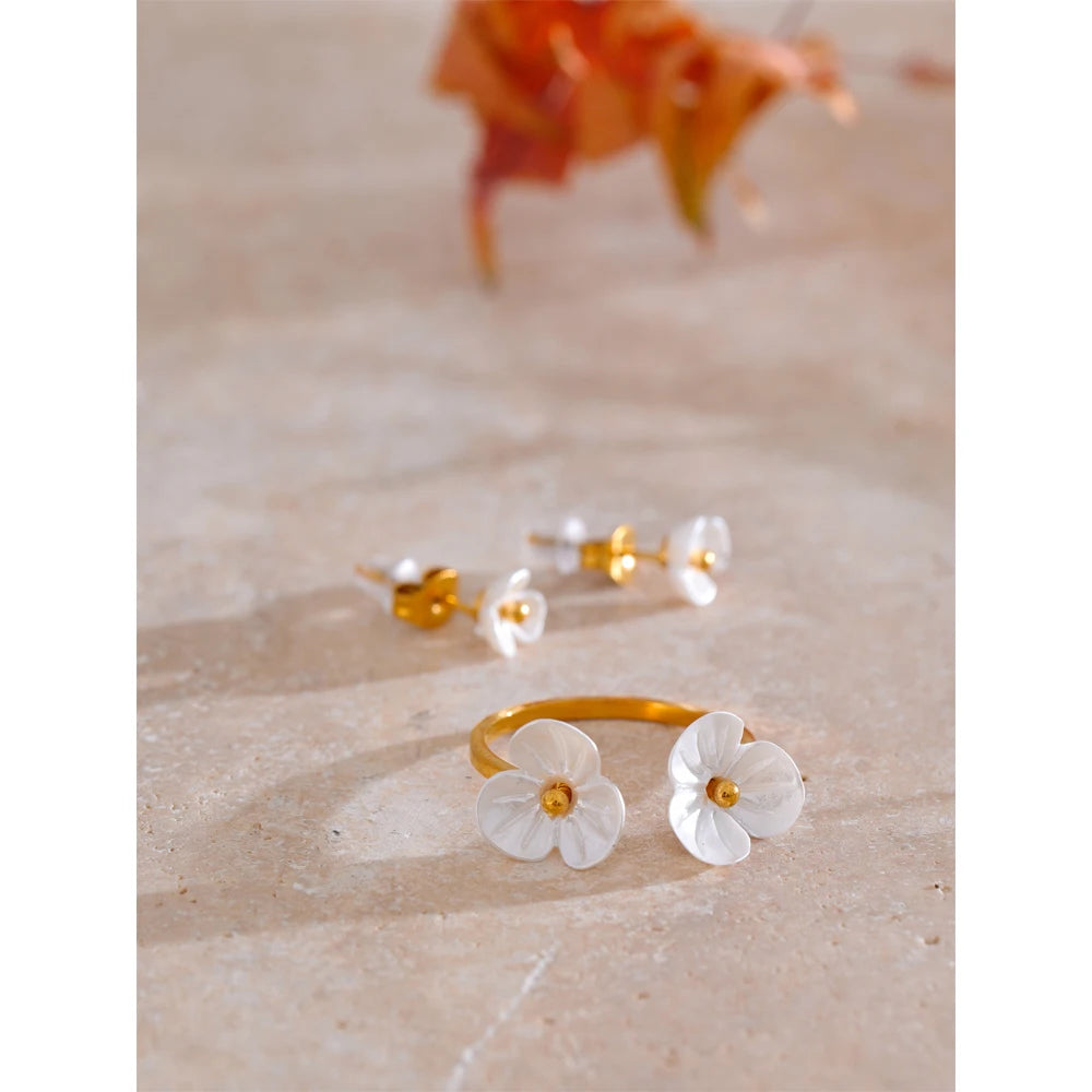 Rhea Blossom flower ring and earrings styled on travertine
