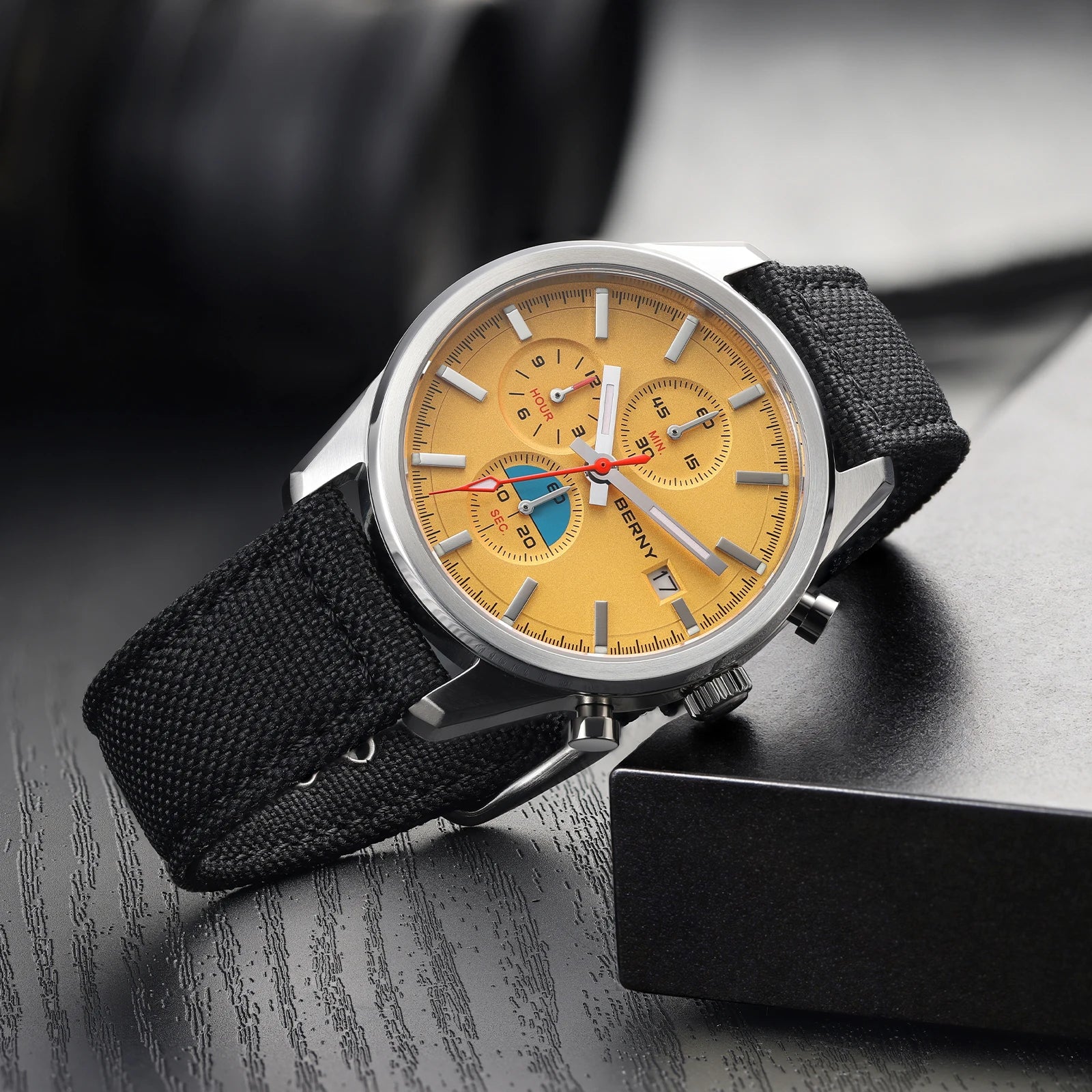 Kestrel chronograph sport watch, amber dial, resting on a dark ledge