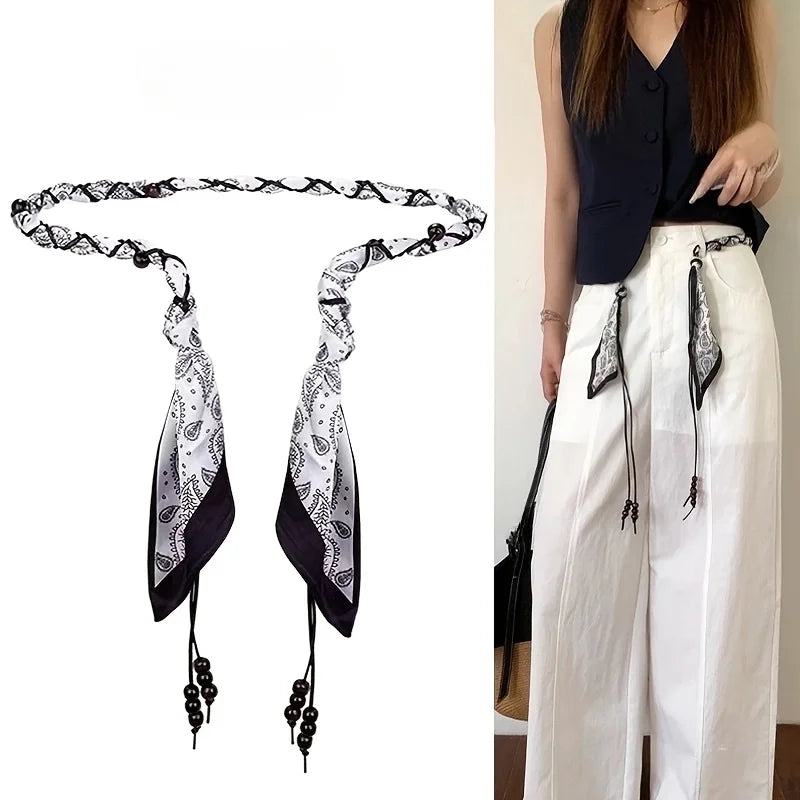 Ivy woven scarf belt in black paisley, laid flat and worn at the waist