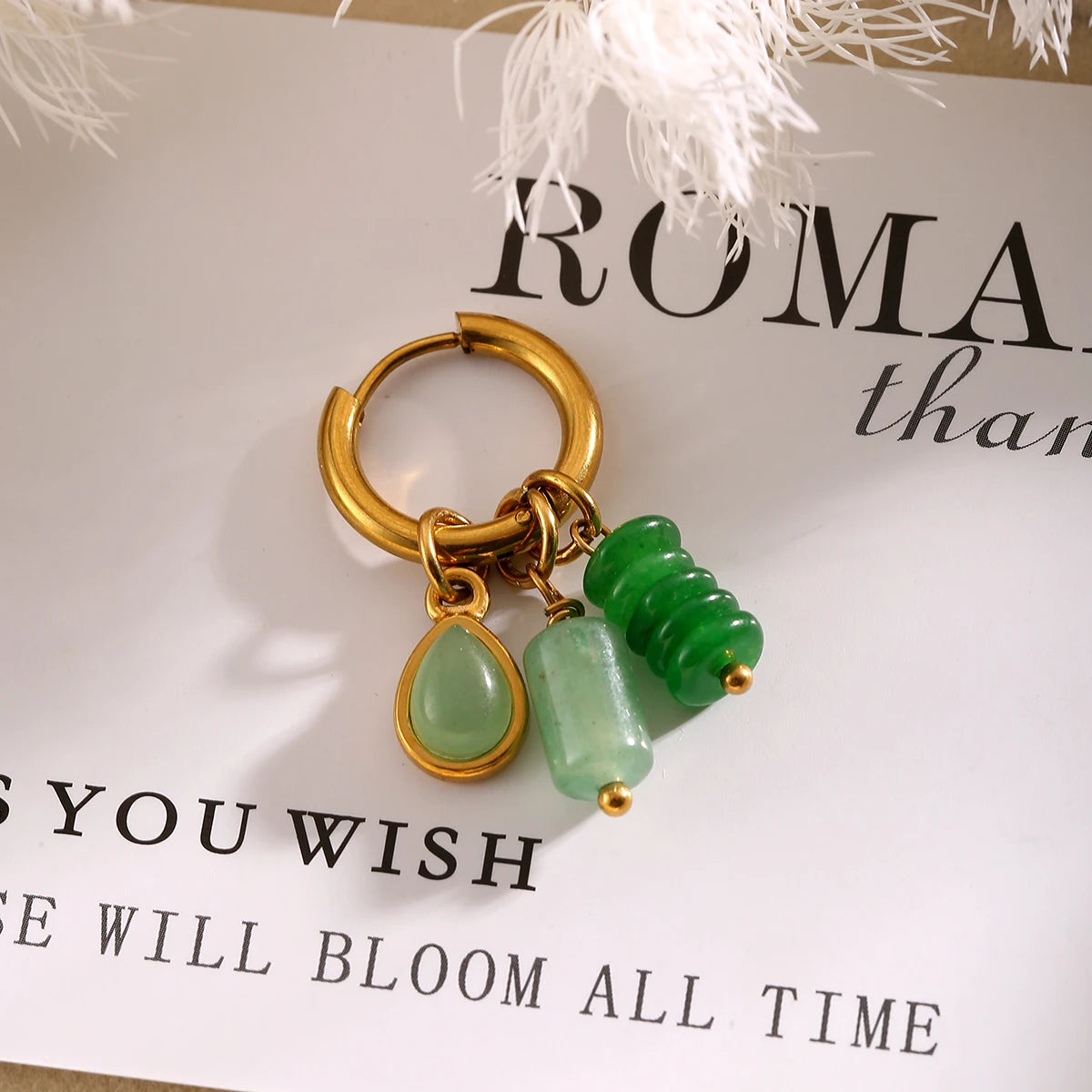 Sedona Charm Huggie Hoops in Green, styled flat lay