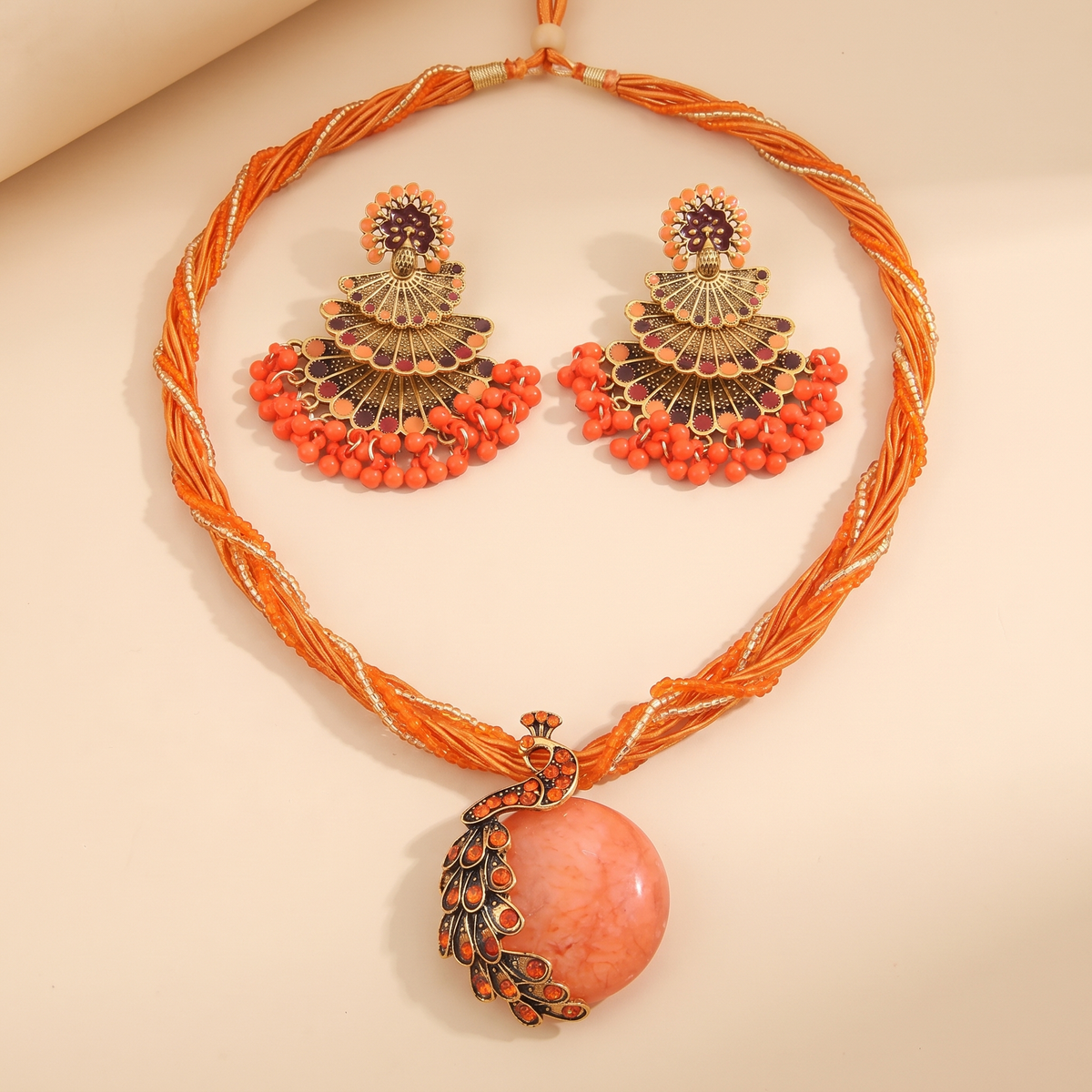 Alba Peacock Jewelry Set in Coral Orange, necklace and matching fan earrings studio flat lay
