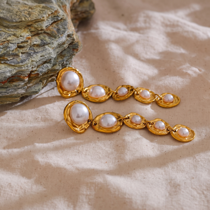 Amelie gold pearl drop earrings on linen