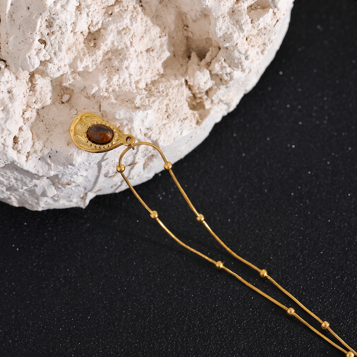Asha Tiger-Eye Pendant close-up on natural stone