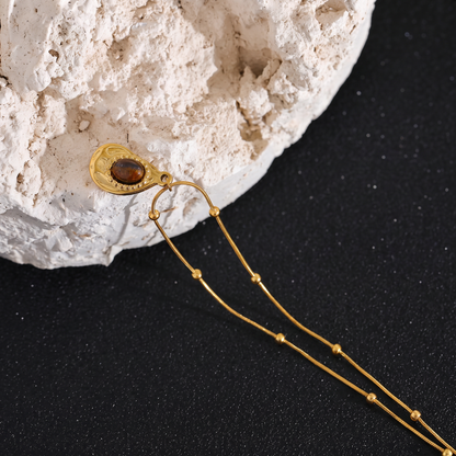 Asha Tiger-Eye Pendant close-up on natural stone