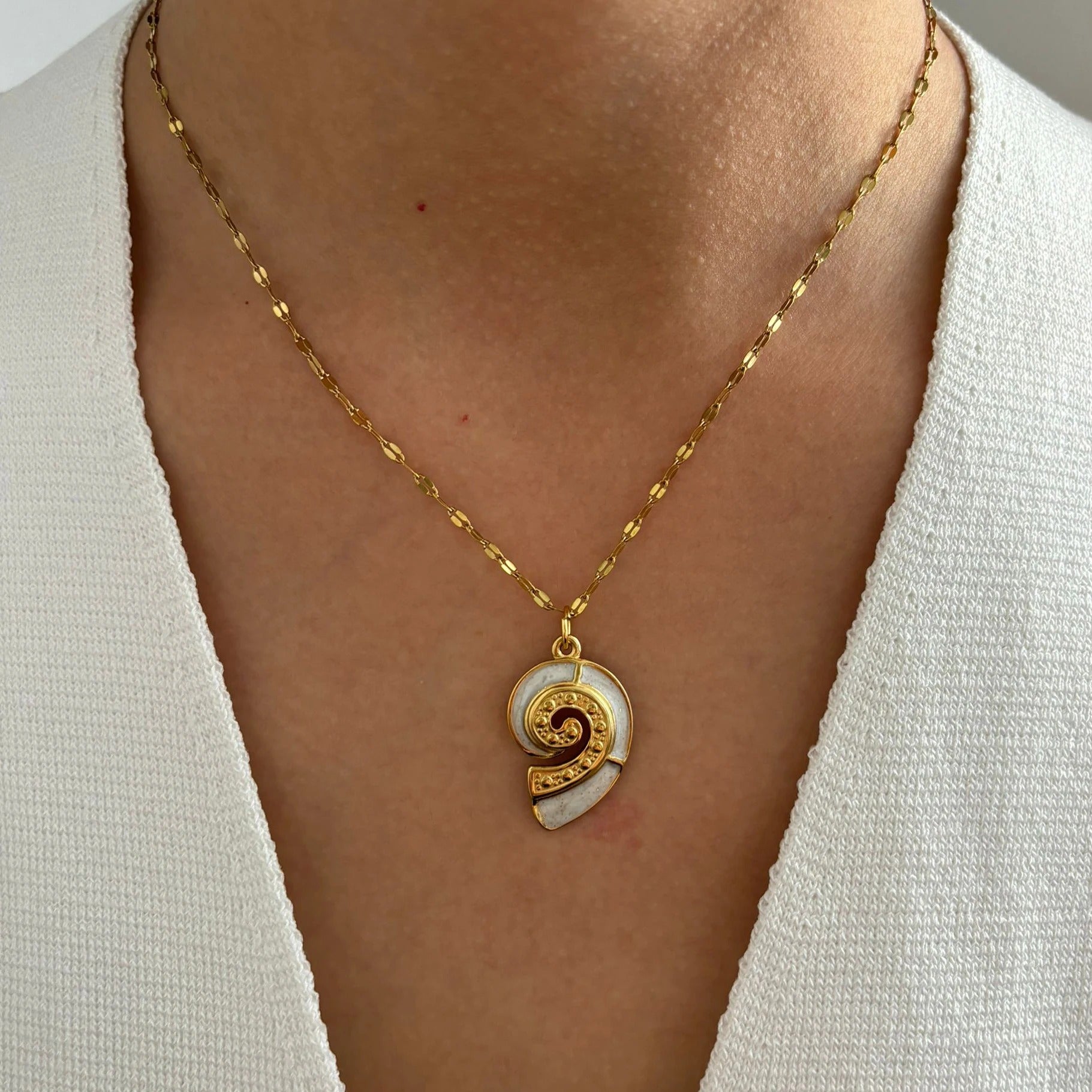 Corsica gold conch shell pendant necklace worn on a model