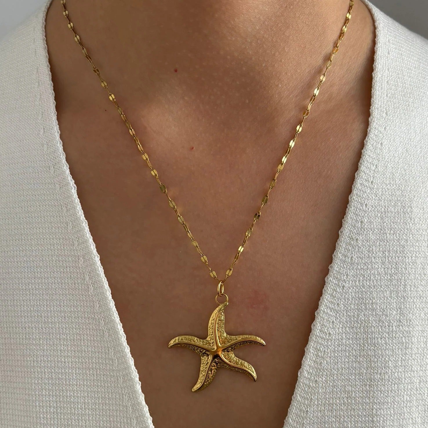 Corsica gold starfish pendant necklace worn on a model