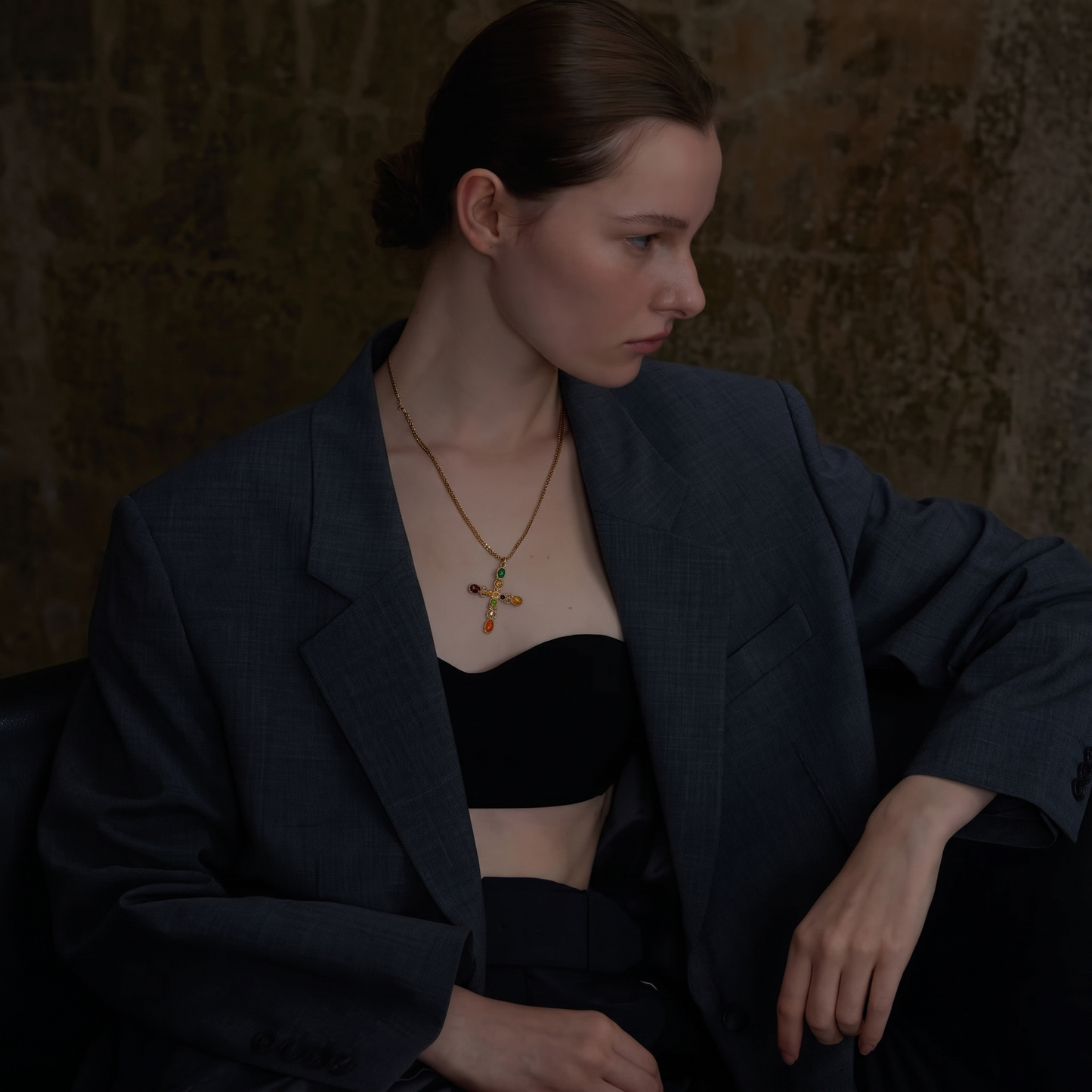 Cruz Multi-Stone Cross Necklace pendant styled on stone with wood accent