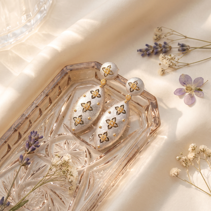 Elena Brushed Clover Drop Earrings on blush glass tray