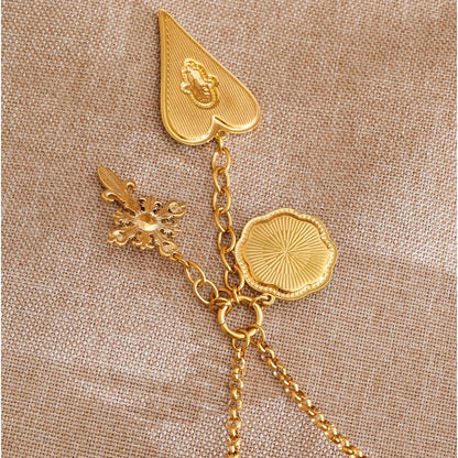 Close-up of the heart, cross and coin charms on the Elise necklace