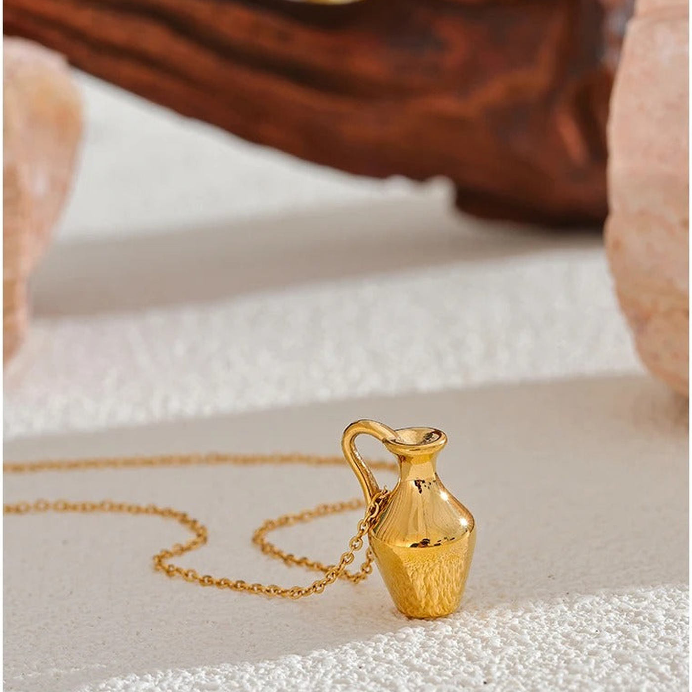 Ravello vase pendant necklace styled on a warm textured surface