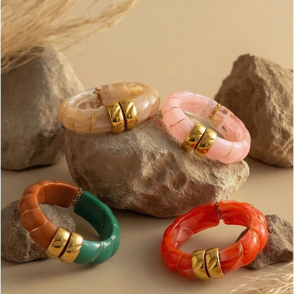 Four Sonoma resin cuff bangle colorways arranged on stone