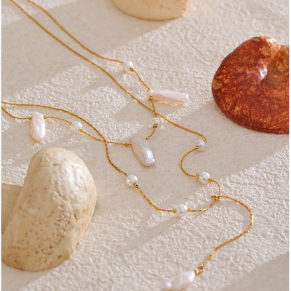 Catalina baroque pearl necklace styled flat lay with coral and stone