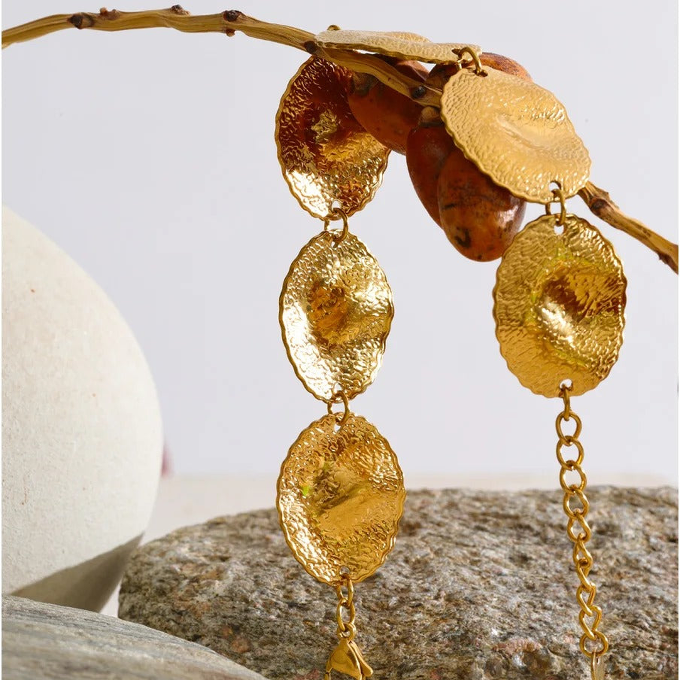 Blakely hammered gold-tone disc bracelet hanging from a branch