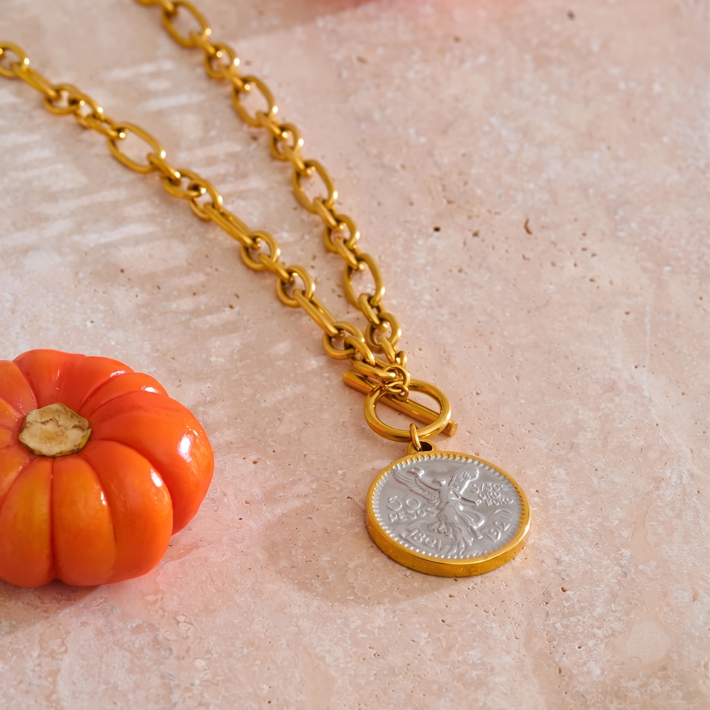 Gabrielle gold coin necklace styled on stone