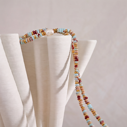 Livia Aqua Terra beaded jasper necklace draped over ribbed white ceramic