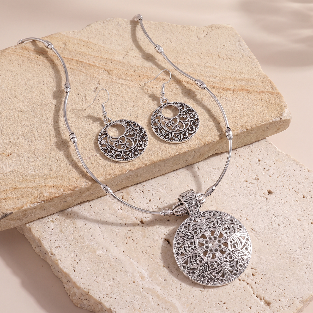 Lucca medallion jewelry set arranged on tiered stone
