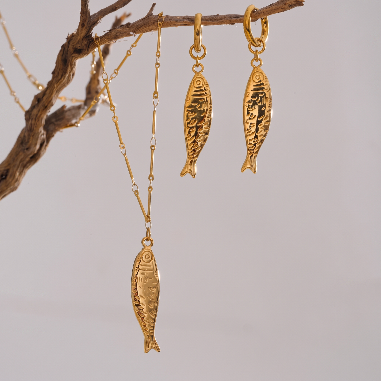 Oceane gold fish necklace and earrings hanging