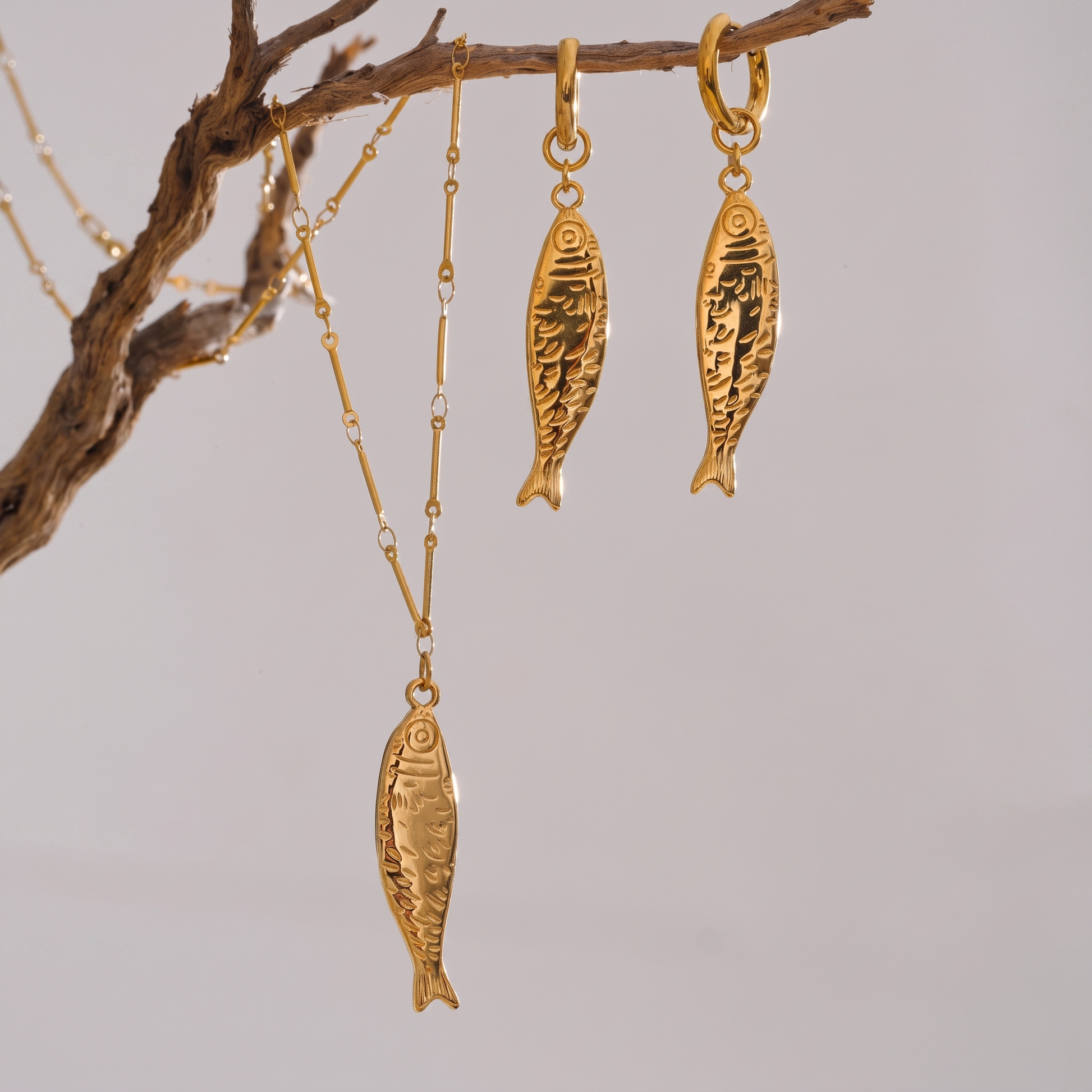 Oceane gold fish necklace and earrings hanging