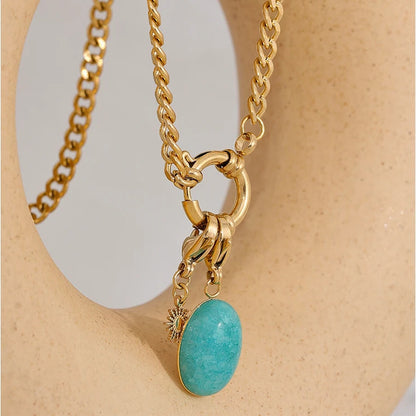 Orla Aqua Stone Necklace with oval aqua stone pendant on a warm sculptural stand
