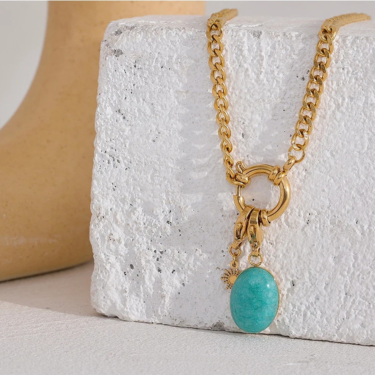 Orla Aqua Stone Necklace curb chain and aqua stone pendant styled on a textured stone block