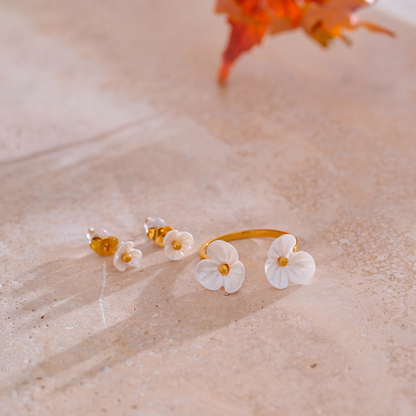 Rhea Blossom white resin flower ring and stud earrings on stone