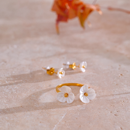 Rhea Blossom flower ring and earrings styled on travertine