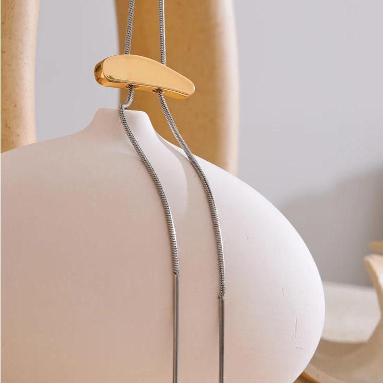 Kai Two-Tone Slide Necklace draped over ceramic vase