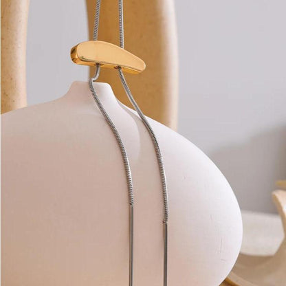 Kai Two-Tone Slide Necklace draped over ceramic vase