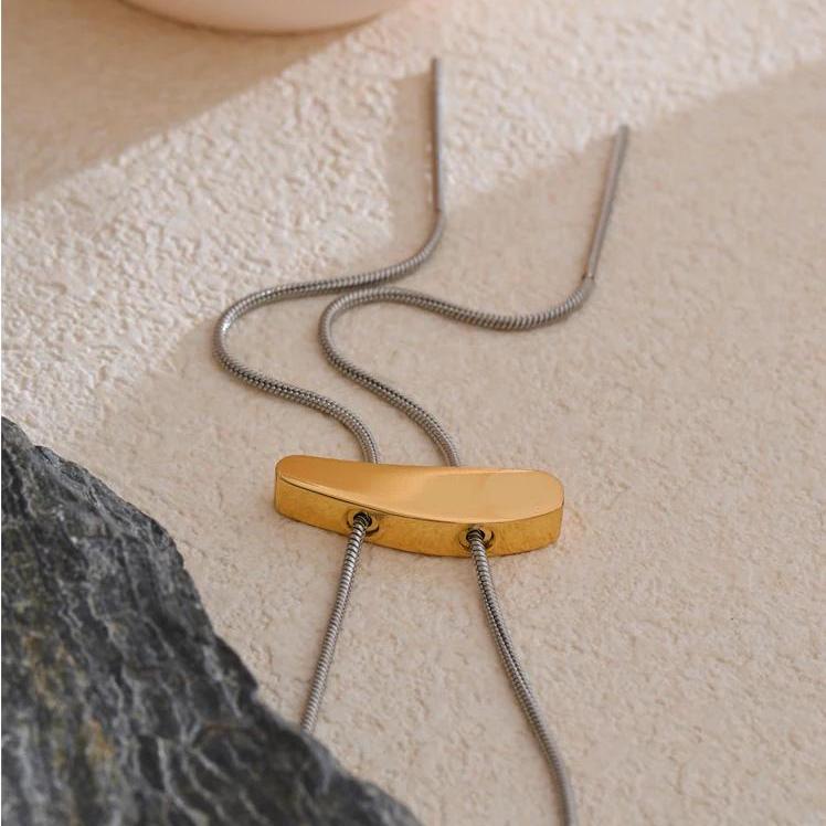 Kai Two-Tone Slide Necklace styled on textured stone surface